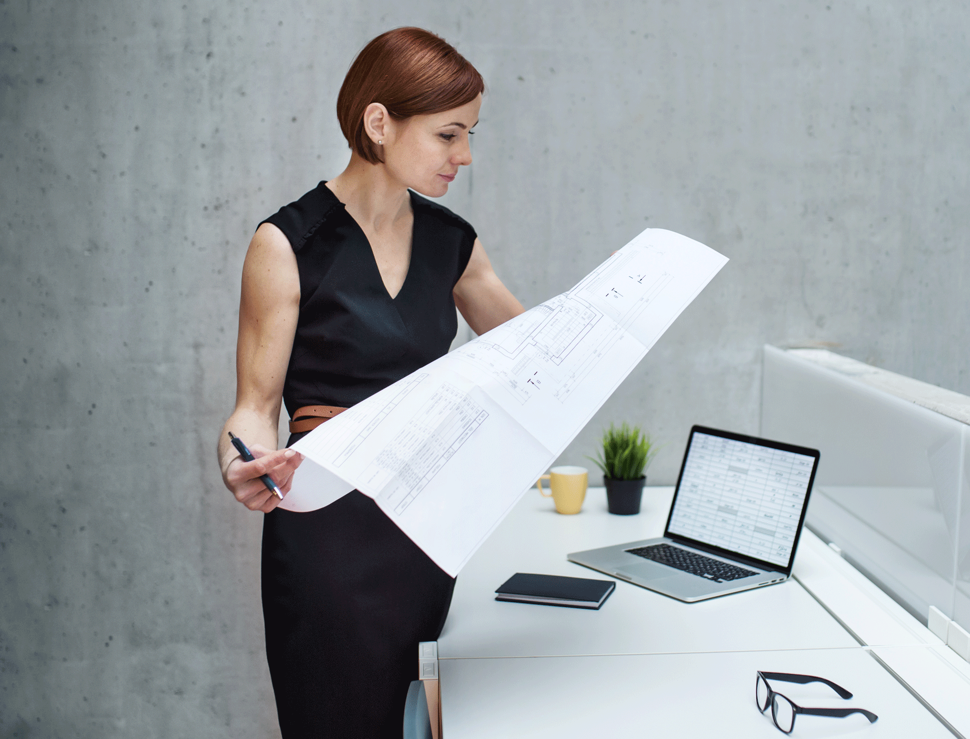 young-businesswoman-or-architect-with-blueprints-a-UMBTJQ7