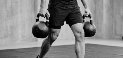 Atleta realizando Farmers Carry con kettlebells O'Live Fitness